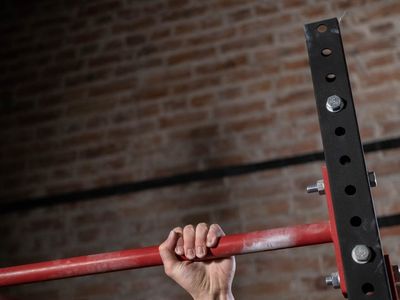 Close-up of hands gripping a pull-up bar firmly.